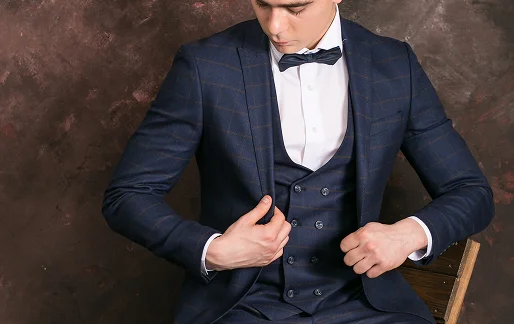 Man in a navy blue plaid suit and bow tie