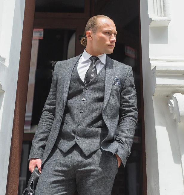 Man in a sharp gray suit, white shirt, and tie