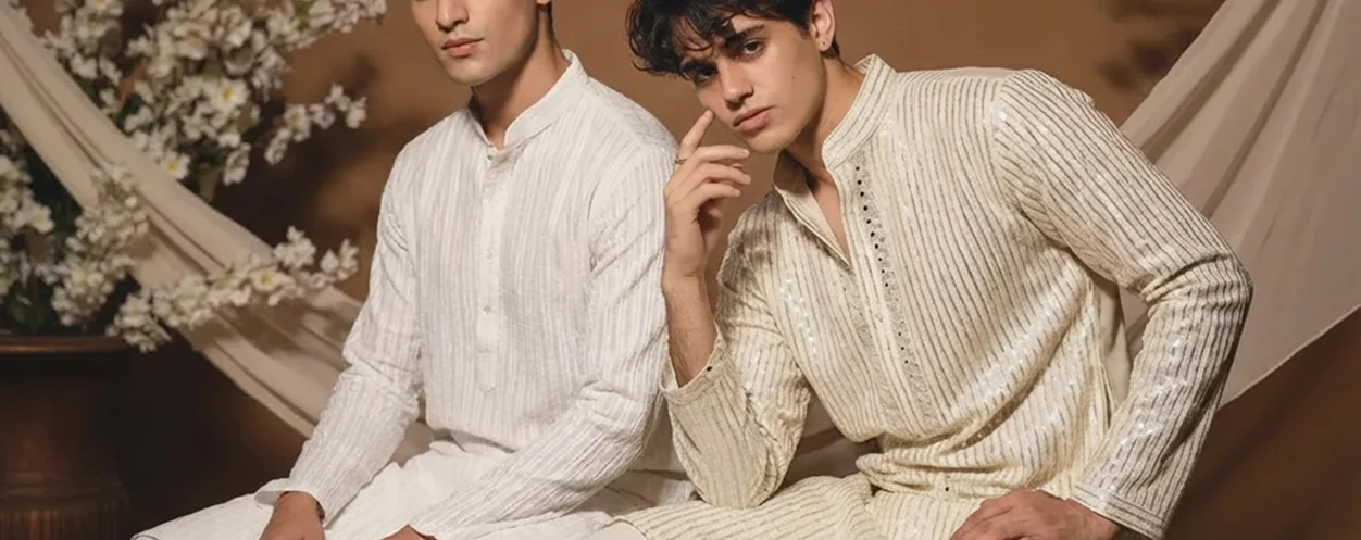 Two men in traditional cream-colored embroidered kurtas