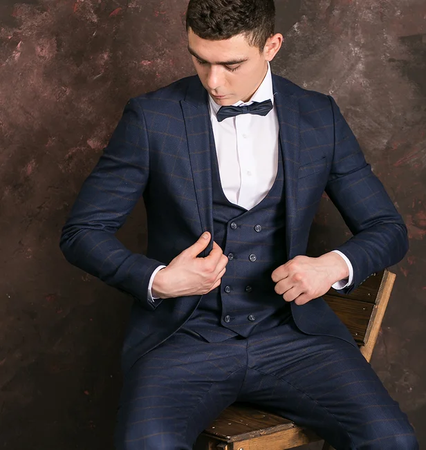 Man in a dark navy plaid suit with a white shirt and bow tie