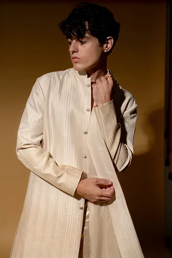 Model wearing a cream-colored traditional outfit