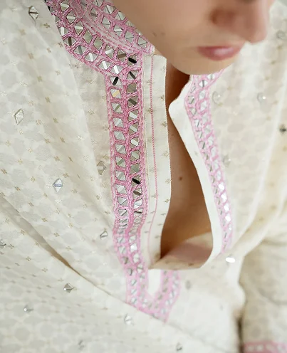 Person wearing a cream-colored patterned outfit