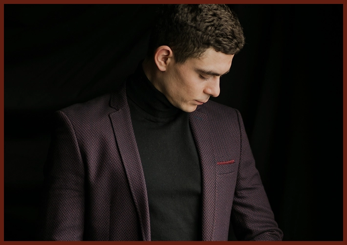 Man in a maroon blazer and black turtleneck